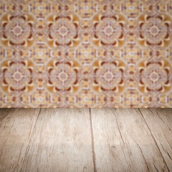 Wood table top and blur vintage ceramic tile pattern wall — Stock Photo, Image