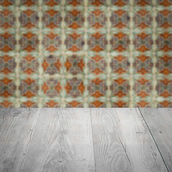 Wood table top and blur vintage ceramic tile pattern wall — Stock Photo, Image