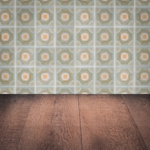 Wood table top and blur vintage ceramic tile pattern wall — Stock Photo, Image