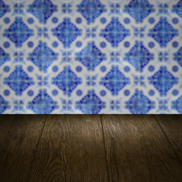 Wood table top and blur vintage ceramic tile pattern wall — Stock Photo, Image