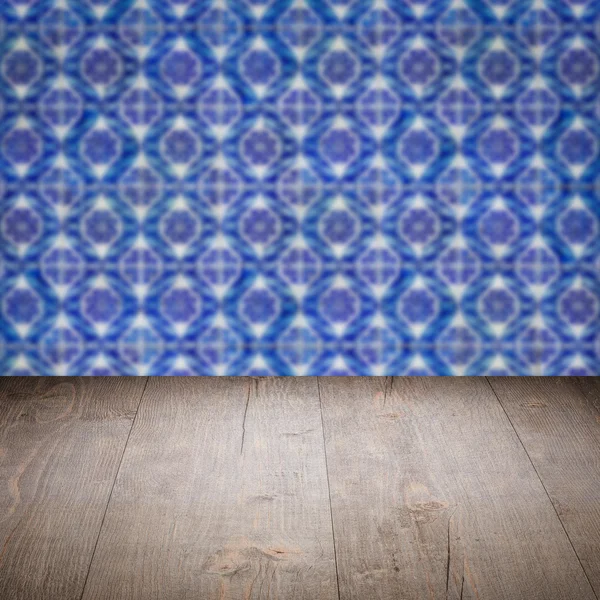 Wood table top and blur vintage ceramic tile pattern wall — Stock Photo, Image