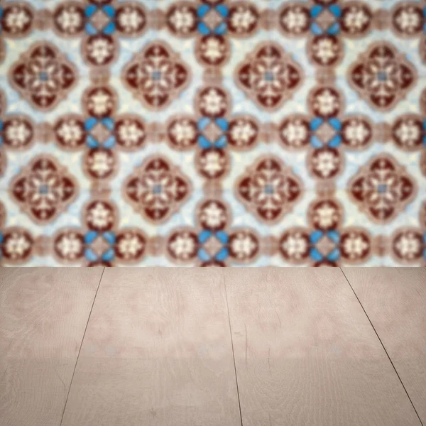 Wood table top and blur vintage ceramic tile pattern wall — Stock Photo, Image