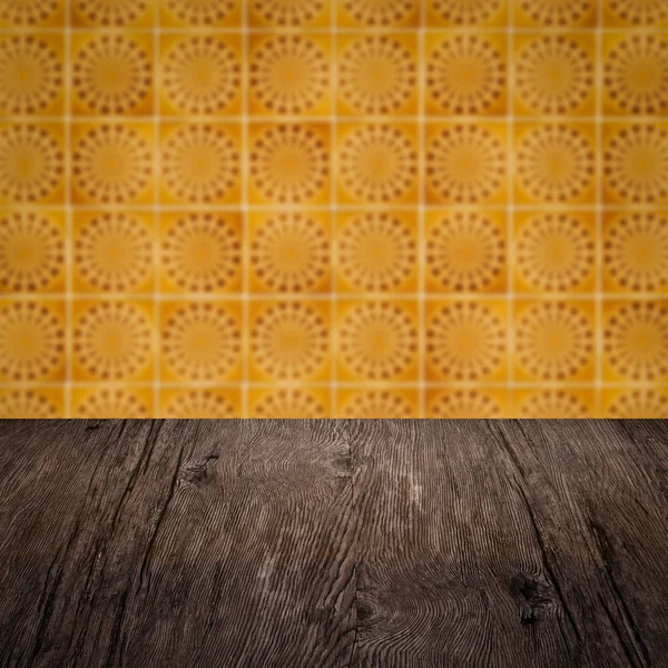 Wood table top and blur vintage ceramic tile pattern wall — Stock Photo, Image