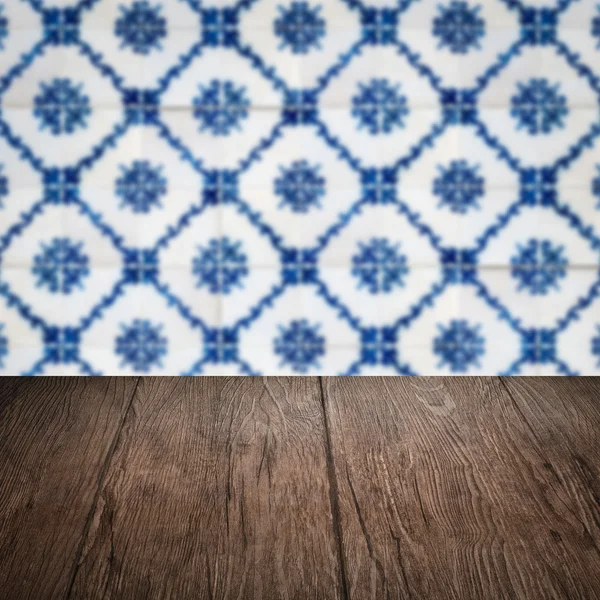 Wood table top and blur vintage ceramic tile pattern wall — Stock Photo, Image