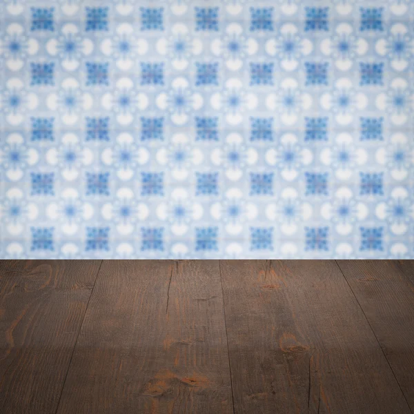 Wood table top and blur vintage ceramic tile pattern wall — Stock Photo, Image