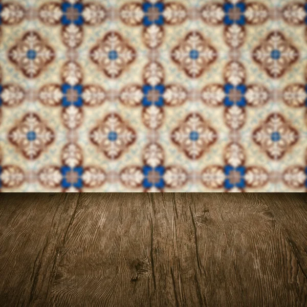 Wood table top and blur vintage ceramic tile pattern wall — Stock Photo, Image