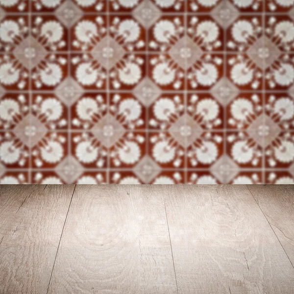 Wood table top and blur vintage ceramic tile pattern wall — Stock Photo, Image