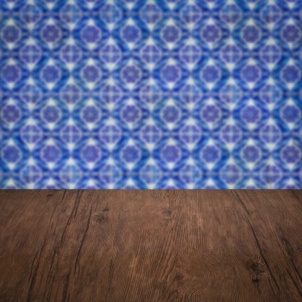 Wood table top and blur vintage ceramic tile pattern wall — Stock Photo, Image