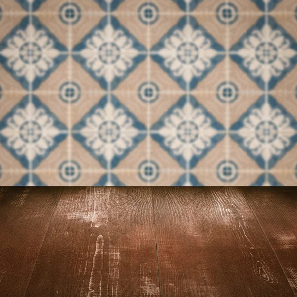 Wood table top and blur vintage ceramic tile pattern wall — Stock Photo, Image