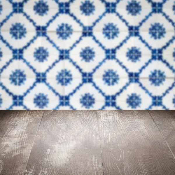 Wood table top and blur vintage ceramic tile pattern wall — Stock Photo, Image