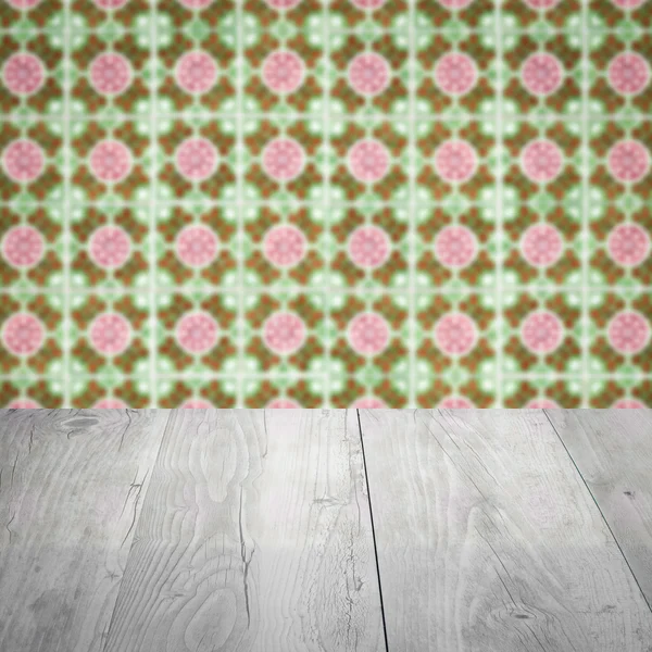 Wood table top and blur vintage ceramic tile pattern wall — Stock Photo, Image