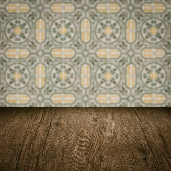 Wood table top and blur vintage ceramic tile pattern wall — Stock Photo, Image