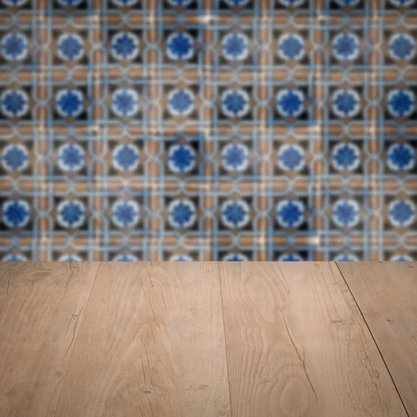 Wood table top and blur vintage ceramic tile pattern wall — Stock Photo, Image