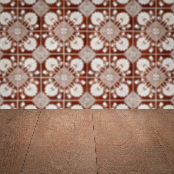 Wood table top and blur vintage ceramic tile pattern wall — Stock Photo, Image