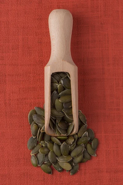 Colher de madeira com sementes de abóbora — Fotografia de Stock