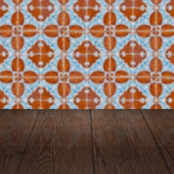 Wood table top and blur vintage ceramic tile pattern wall — Stock Photo, Image