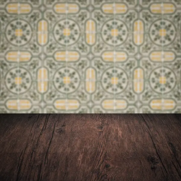 Wood table top and blur vintage ceramic tile pattern wall — Stock Photo, Image