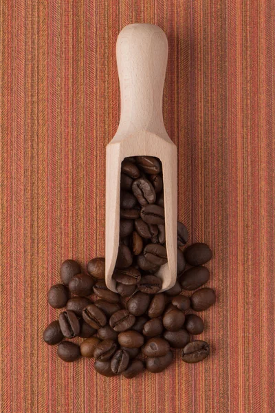 Wooden scoop with coffee beans — Stock Photo, Image