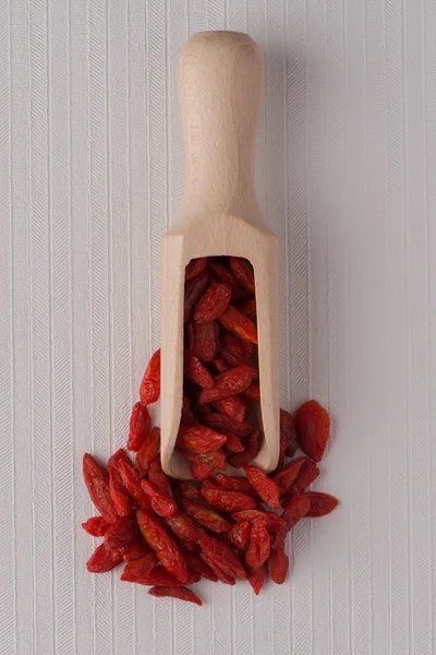 Pala de madera con bayas rojas secas de goji — Foto de Stock