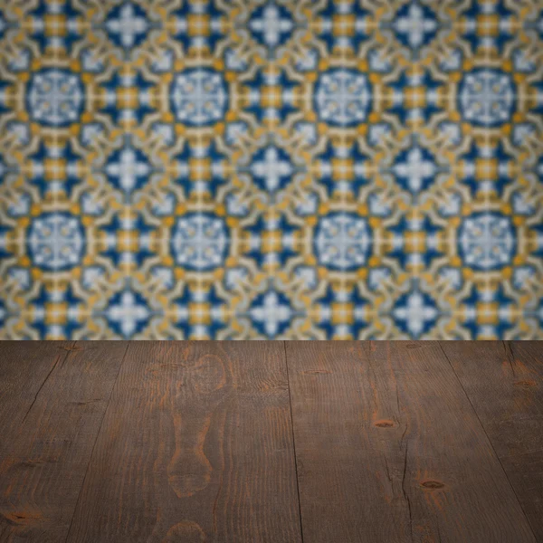 Wood table top and blur vintage ceramic tile pattern wall — Stock Photo, Image