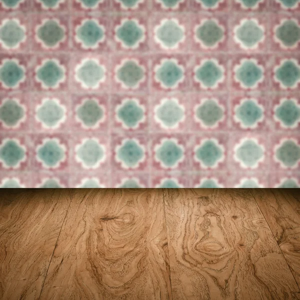 Wood table top and blur vintage ceramic tile pattern wall — Stock Photo, Image