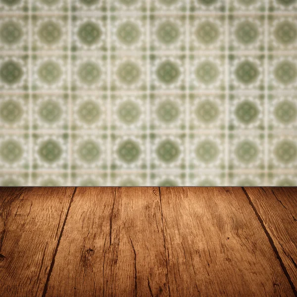 Wood table top and blur vintage ceramic tile pattern wall — Stock Photo, Image