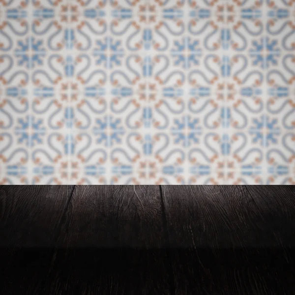 Wood table top and blur vintage ceramic tile pattern wall — Stock Photo, Image