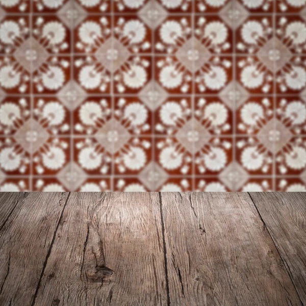 Wood table top and blur vintage ceramic tile pattern wall — Stock Photo, Image