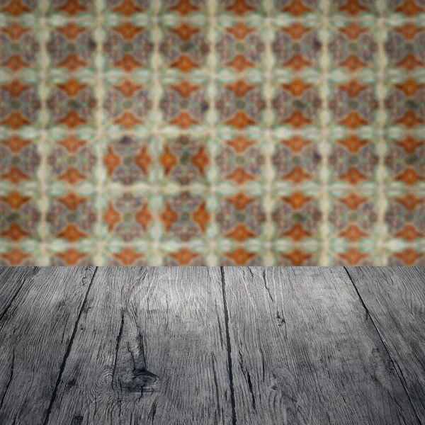 Wood table top and blur vintage ceramic tile pattern wall — Stock Photo, Image