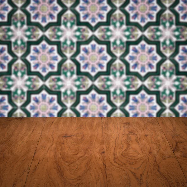 Wood table top and blur vintage ceramic tile pattern wall — Stock Photo, Image