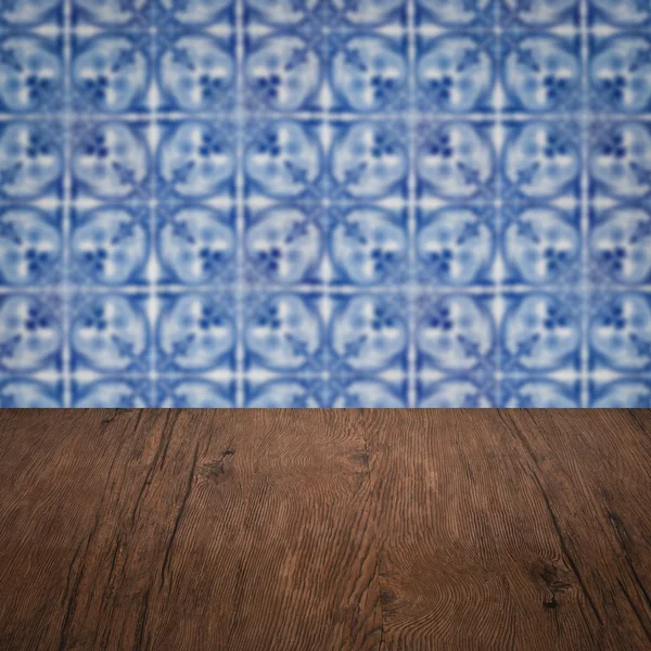 Wood table top and blur vintage ceramic tile pattern wall — Stock Photo, Image