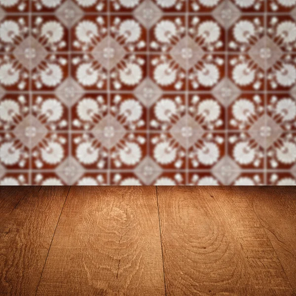 Wood table top and blur vintage ceramic tile pattern wall — Stock Photo, Image