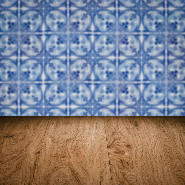 Wood table top and blur vintage ceramic tile pattern wall — Stock Photo, Image