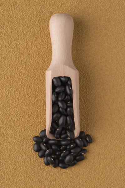 Wooden scoop with black beans — Stock Photo, Image