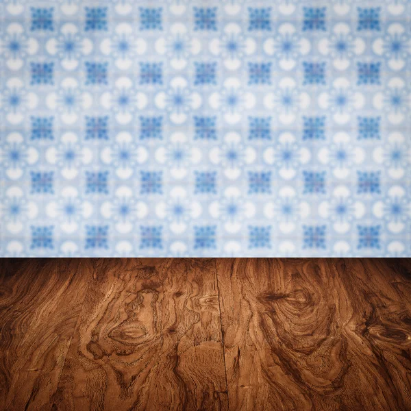 Wood table top and blur vintage ceramic tile pattern wall — Stock Photo, Image