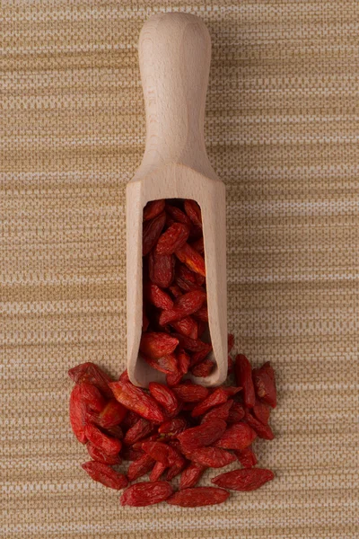 Pala de madera con bayas rojas secas de goji — Foto de Stock