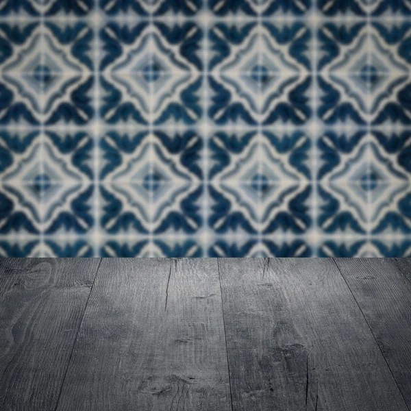 Wood table top and blur vintage ceramic tile pattern wall — Stock Photo, Image