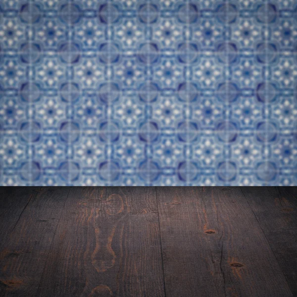 Wood table top and blur vintage ceramic tile pattern wall — Stock Photo, Image