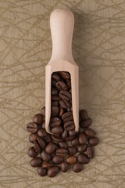 Wooden scoop with coffee beans — Stock Photo, Image