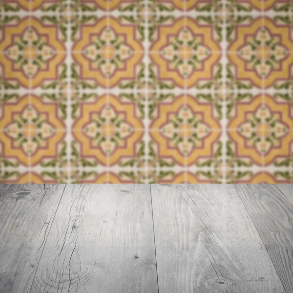 Wood table top and blur vintage ceramic tile pattern wall — Stock Photo, Image