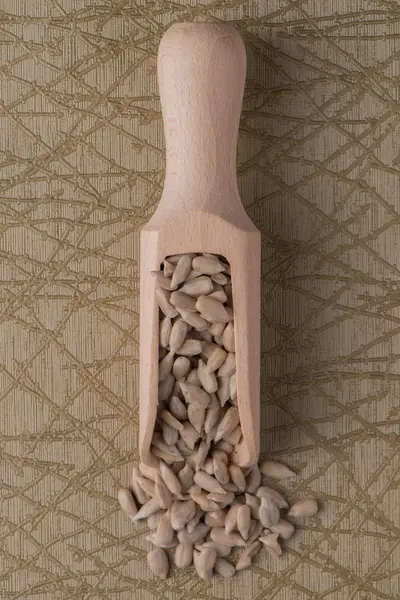 Wooden scoop with shelled sunflower seeds — Stock Photo, Image