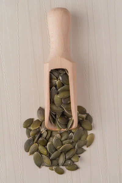 Pala de madera con semillas de calabaza —  Fotos de Stock