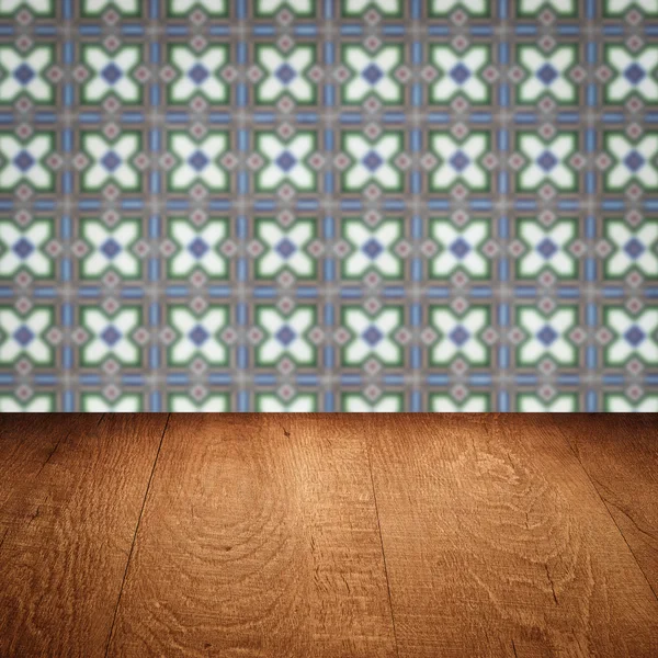 Wood table top and blur vintage ceramic tile pattern wall — Stock Photo, Image