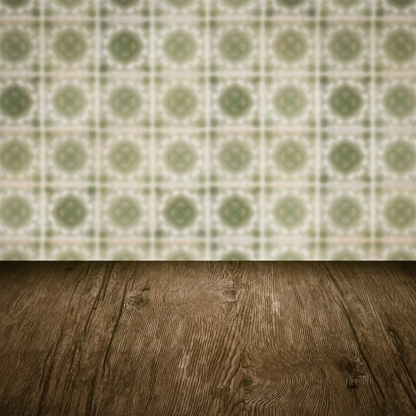 Wood table top and blur vintage ceramic tile pattern wall — Stock Photo, Image