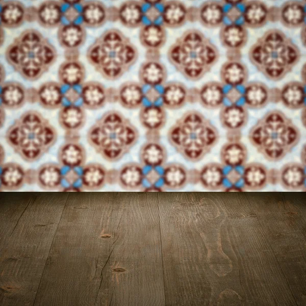 Wood table top and blur vintage ceramic tile pattern wall — Stock Photo, Image