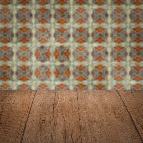 Wood table top and blur vintage ceramic tile pattern wall — Stock Photo, Image