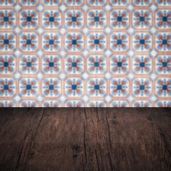 Wood table top and blur vintage ceramic tile pattern wall — Stock Photo, Image