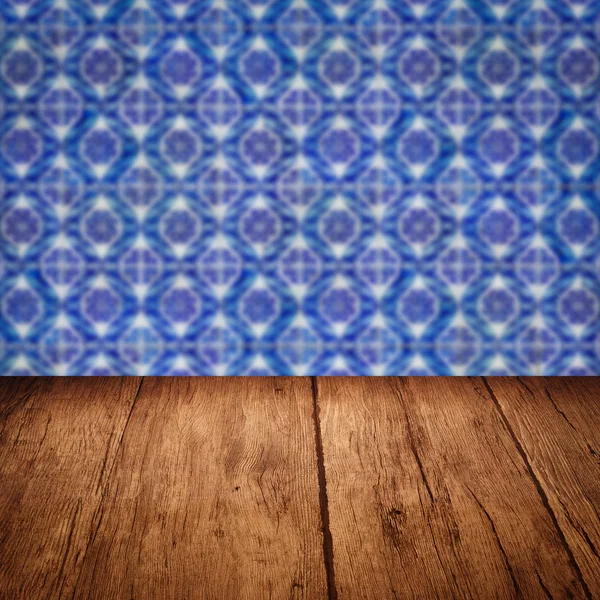 Wood table top and blur vintage ceramic tile pattern wall — Stock Photo, Image