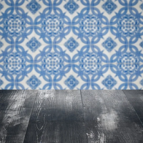 Wood table top and blur vintage ceramic tile pattern wall — Stock Photo, Image