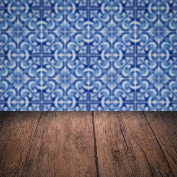 Wood table top and blur vintage ceramic tile pattern wall — Stock Photo, Image